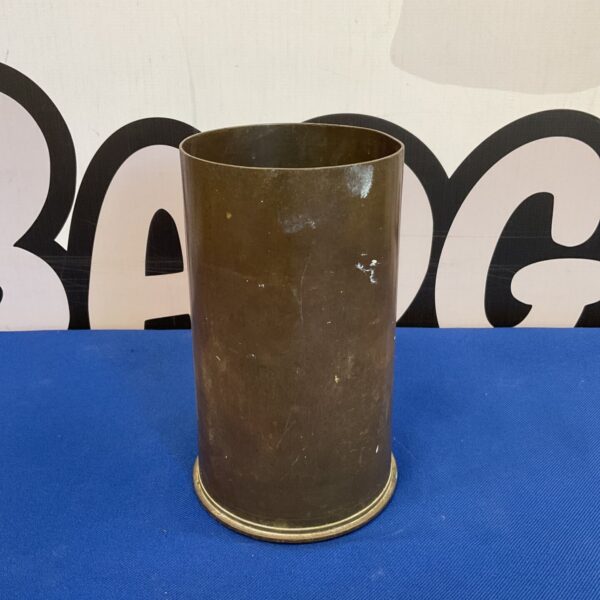 Vintage 1942 WW2 brass shell casing on blue surface.