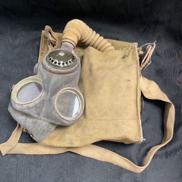 Vintage WWII gas mask and canvas bag, a collectible military item.