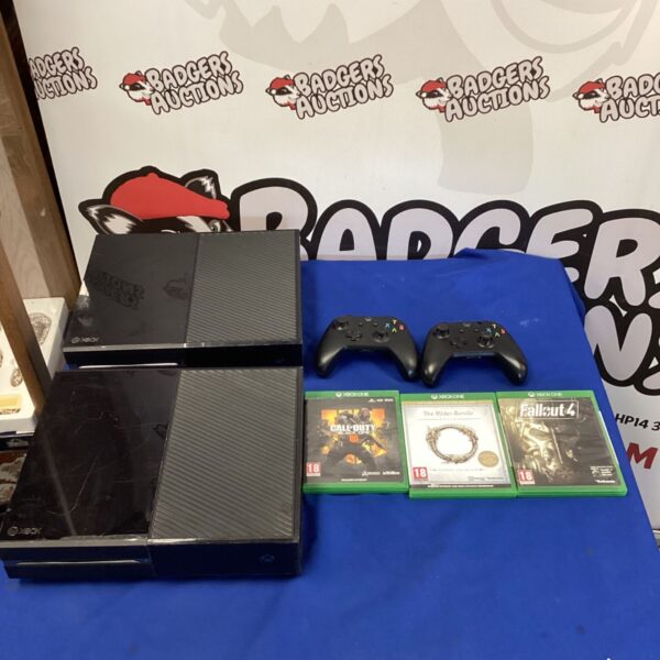 Xbox One console bundle with controllers and game cases.