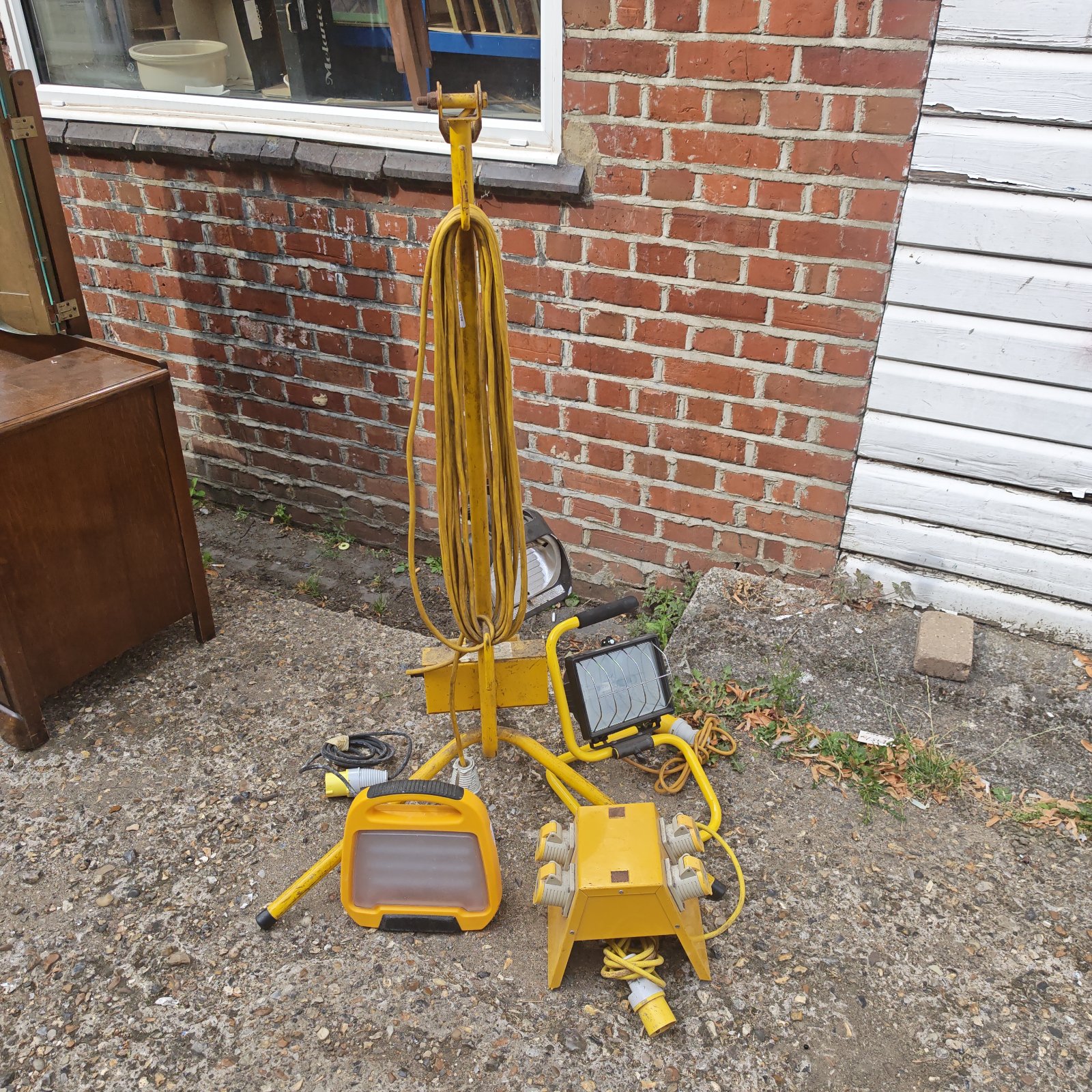 Yellow lead site lamps with stand and power block for construction lighting.