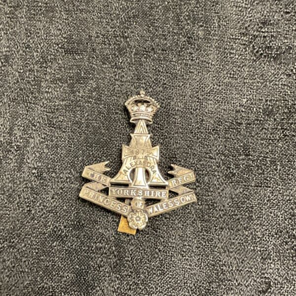 Vintage Yorkshire Regiment cap badge with rose emblem.