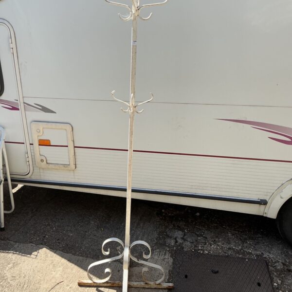 Antique 19th-century iron coat stand in a garden setting.
