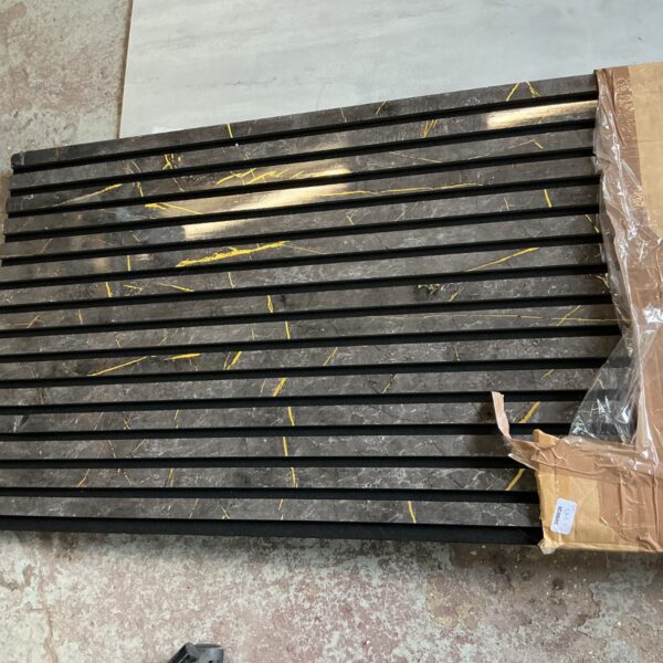 Black and gold acoustic slat wall panels with felt backing.