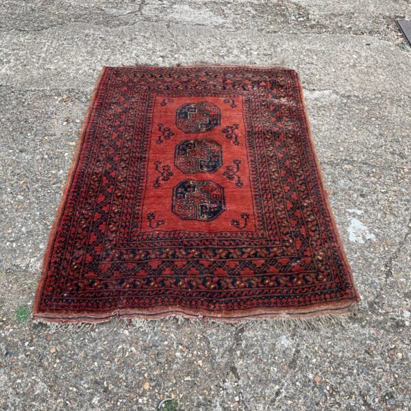 Antique Afghan rug with tassels and geometric design.