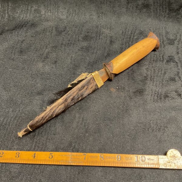 Authentic African tribal knife with hide sheath, a collectible ethnographic weapon.