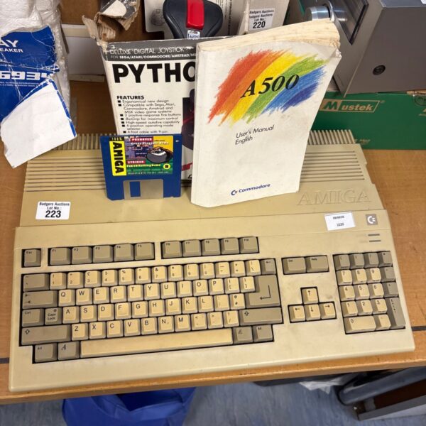 Vintage Amiga A500 computer with joystick and manual for retro gaming.