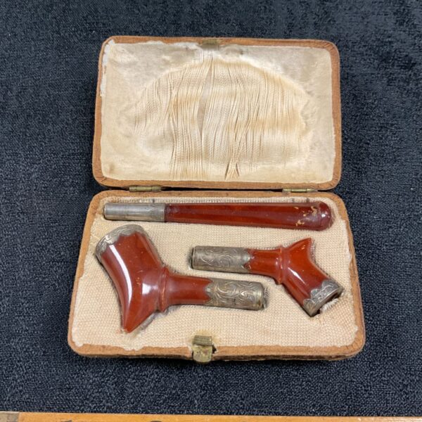 Antique amber cigar holder displayed in its fitted case.