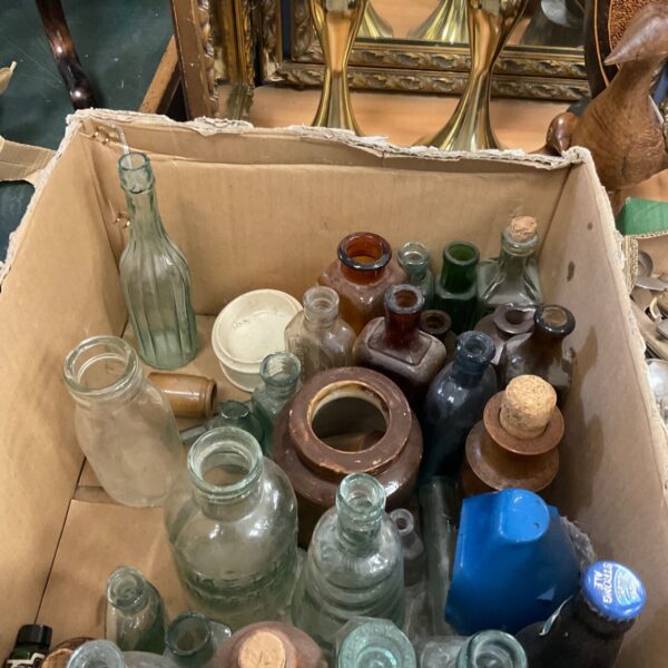 Antique bottle collection with various glass bottles and pots.