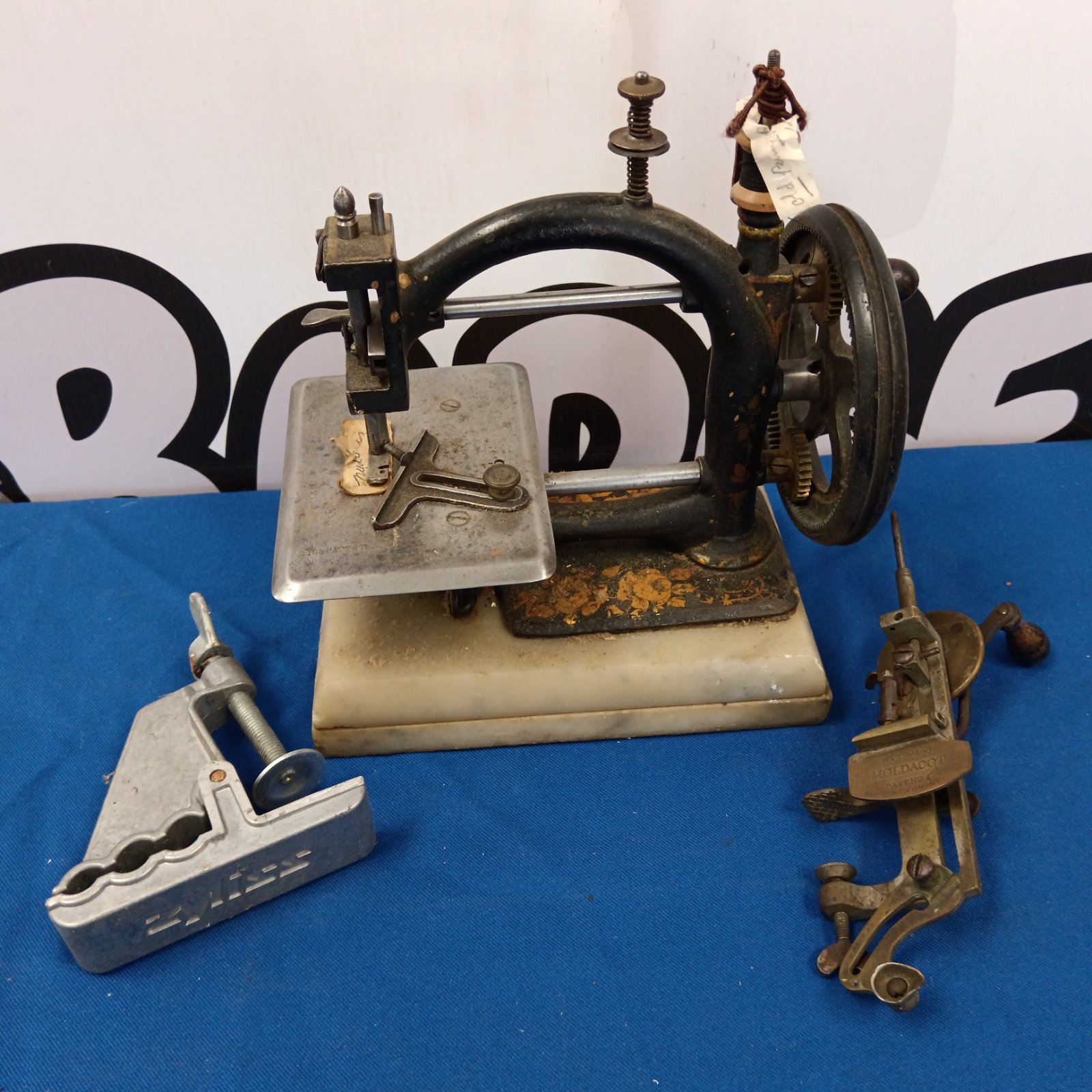 Antique children's sewing machine and Moldacot miniature clamp sewing machine.