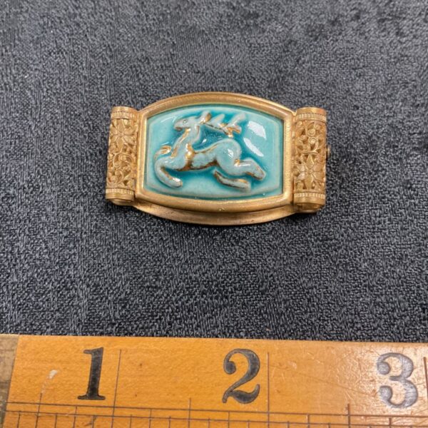 Antique Chinese brooch with intricate filigree and ceramic detail.