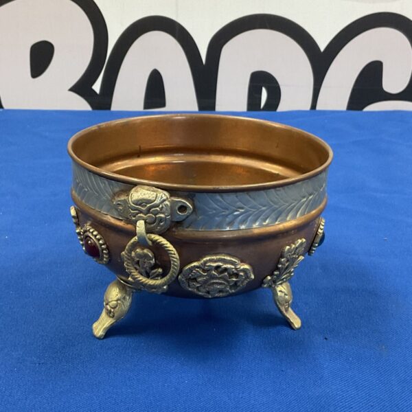 Antique copper bowl with detailed brass feet, vintage collectible.