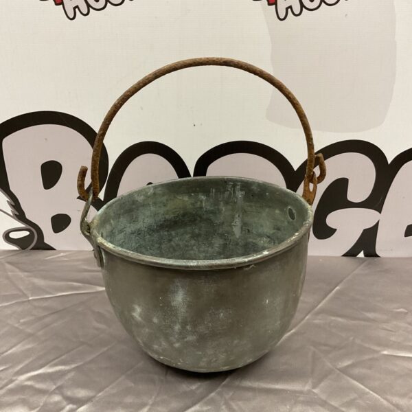 Antique copper cauldron with a weathered patina and sturdy handle.