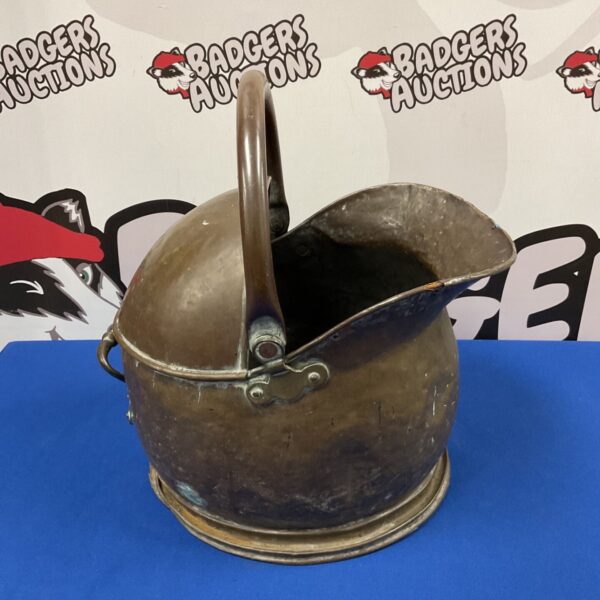 Antique copper coal scuttle with curved handle and patina.
