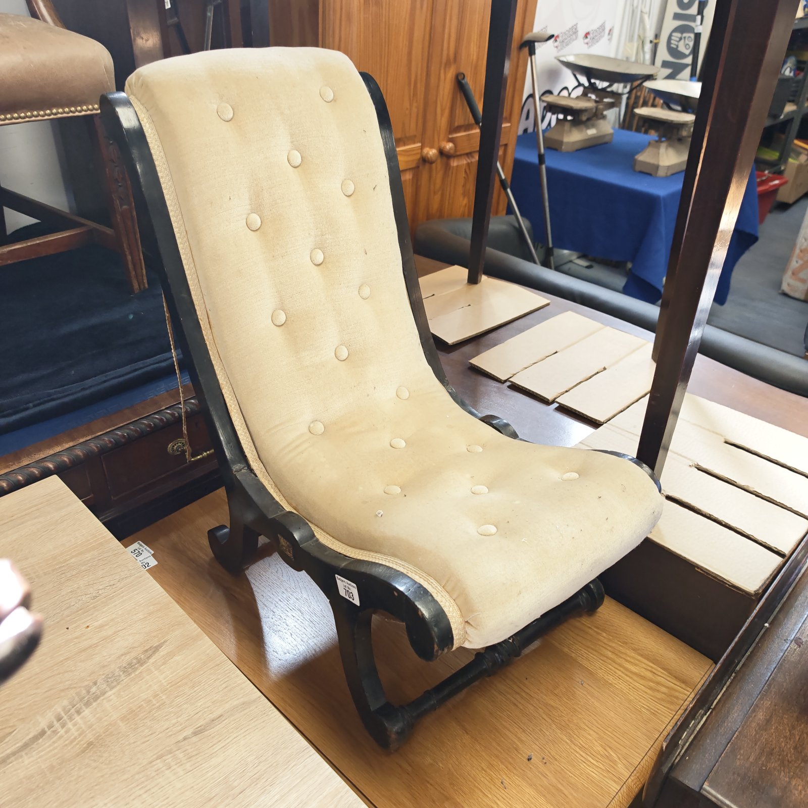 Antique Victorian gout kneeling chair with worn upholstery.