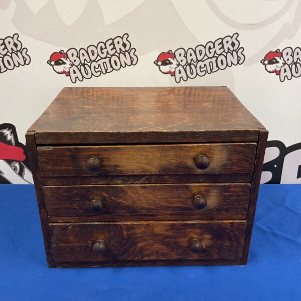 Antique oak collector's drawers with tiered storage and wooden knobs.