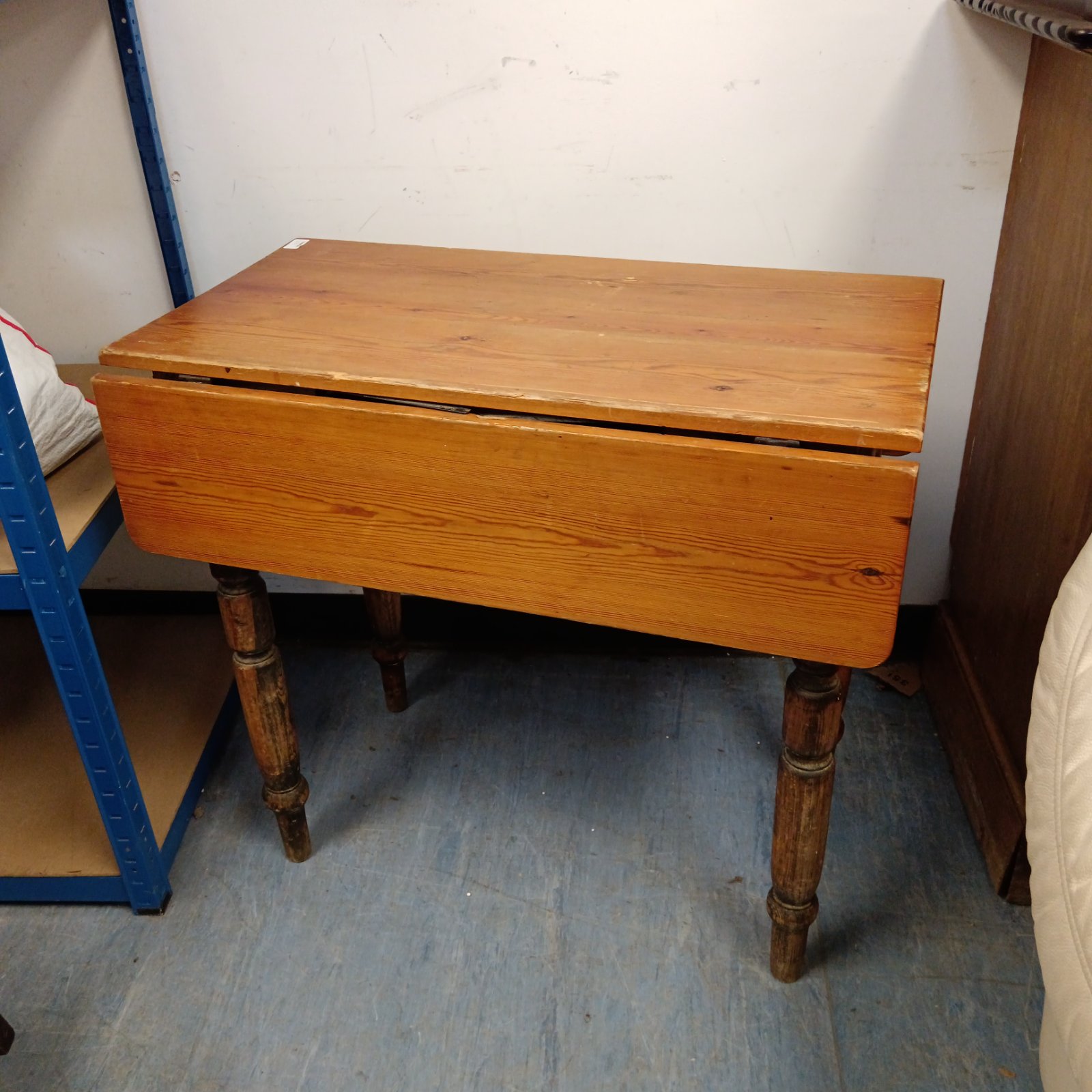 Antique pine drop leaf table with extended leaves and turned legs.
