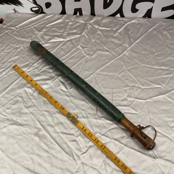 Antique green painted wooden truncheon with measuring tape.