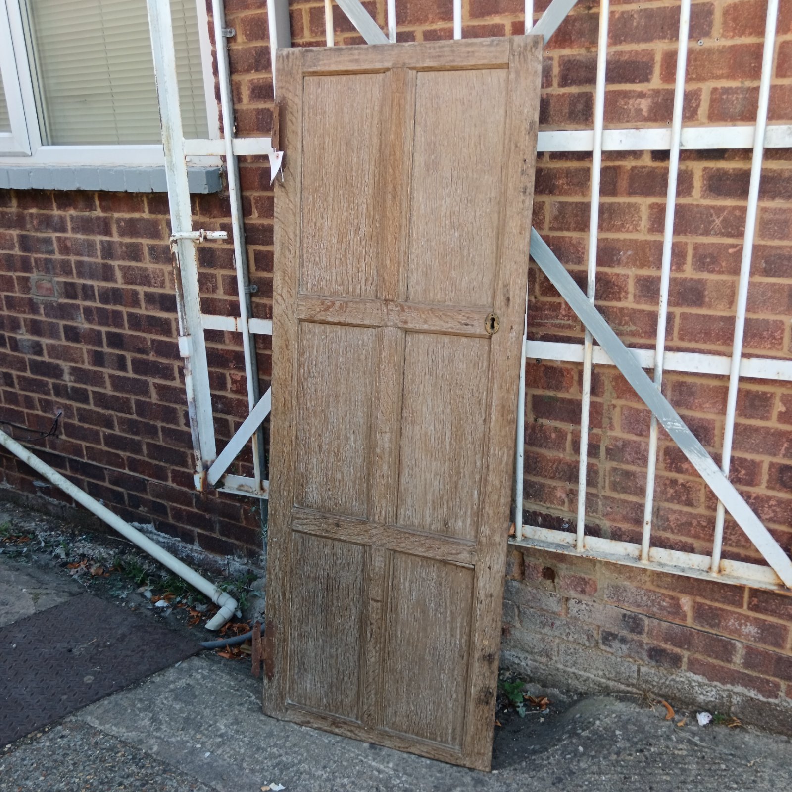 Small antique wooden door against brick wall.