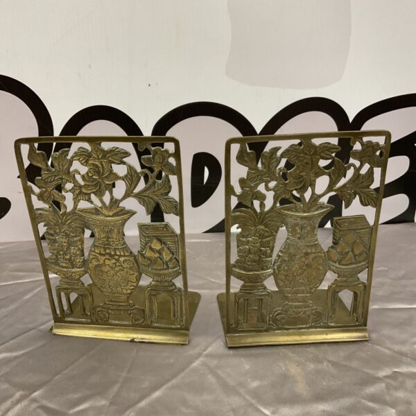 Antique Art Nouveau brass folding bookends with floral design.