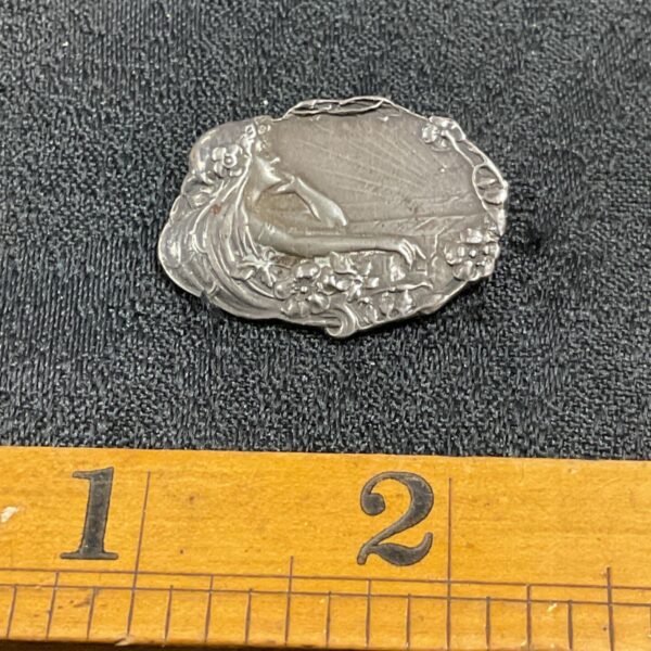Detailed Art Nouveau silver brooch with floral design.