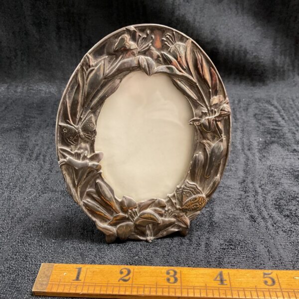 Vintage silver Art Nouveau picture frame with floral and butterfly details.