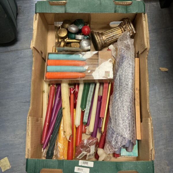 Assorted vintage candle sticks in a cardboard box.