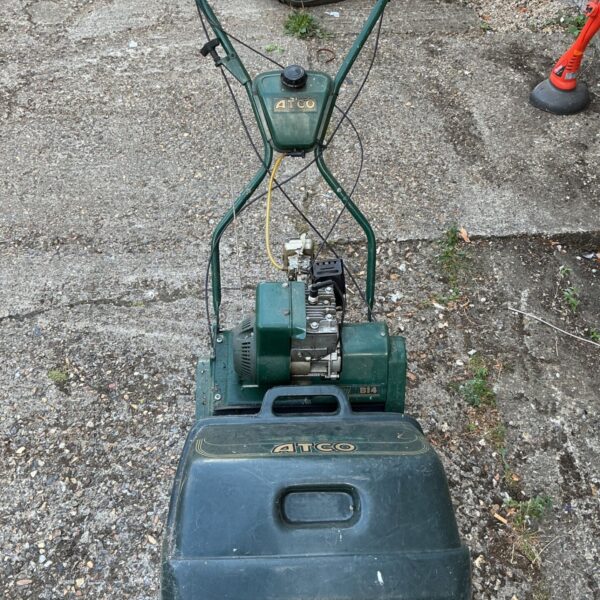 Vintage Atco Balmoral 20se petrol cylinder lawnmower in garden setting.