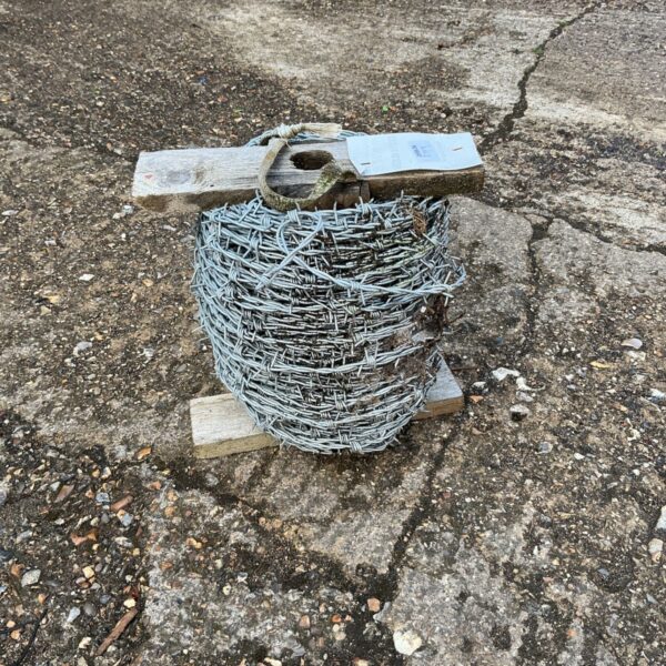 Close-up of a roll of galvanized steel barbed wire.