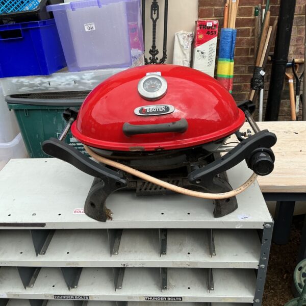 Red Bbqtek gas BBQ with handle and control knob.