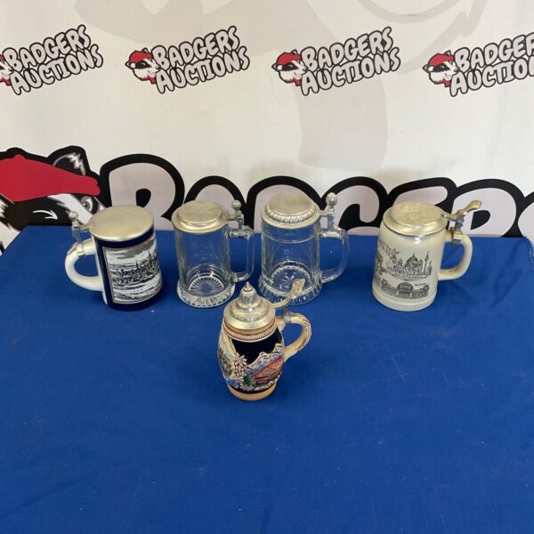 Vintage beer stein collection featuring detailed ceramic designs.
