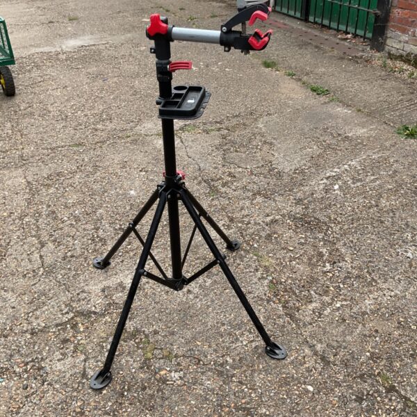 Portable bicycle maintenance stand with tripod base for easy repairs.