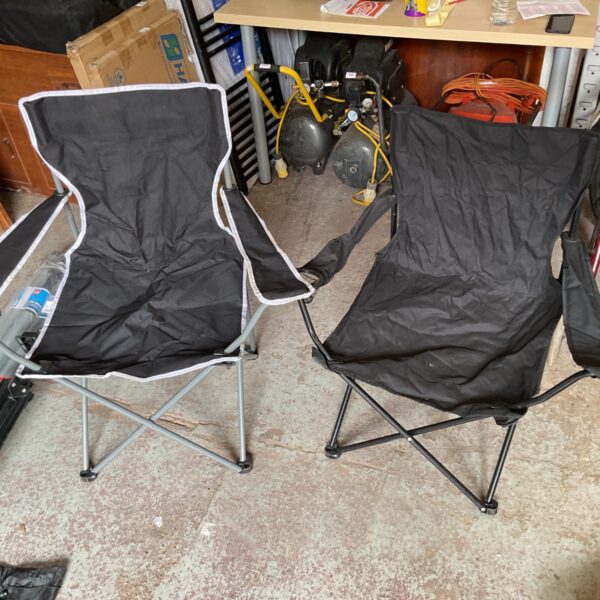 Two black foldaway chairs in a room setting.