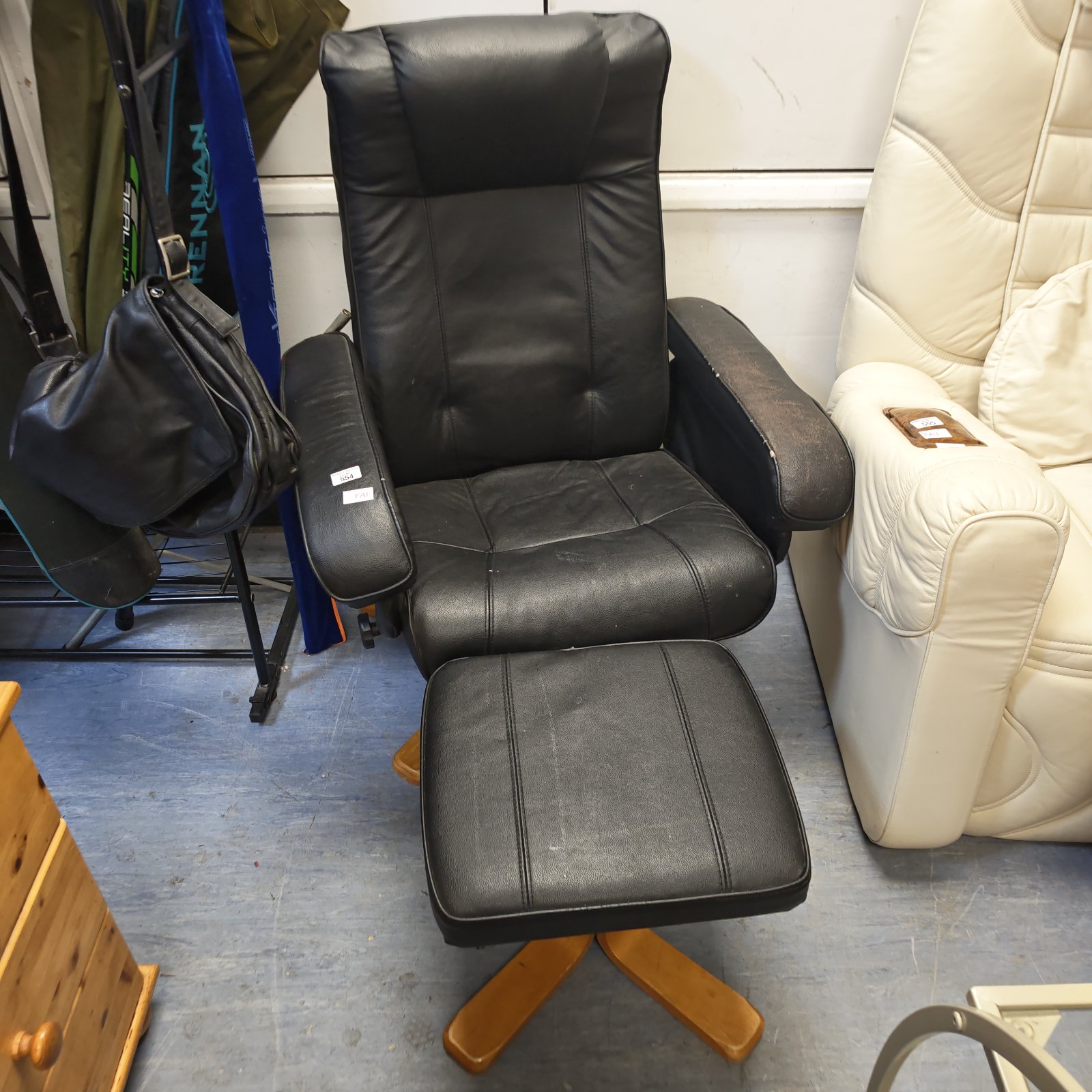 Black leather recliner chair with footstool for comfortable seating.