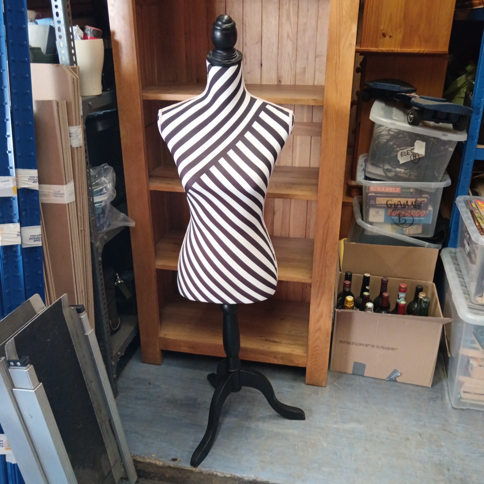 Black and white striped dress form mannequin in a studio setting.