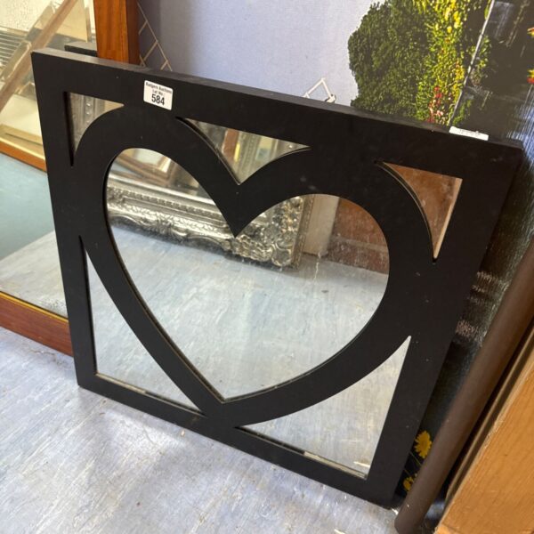 Black wood framed heart shaped mirror for wall decoration.