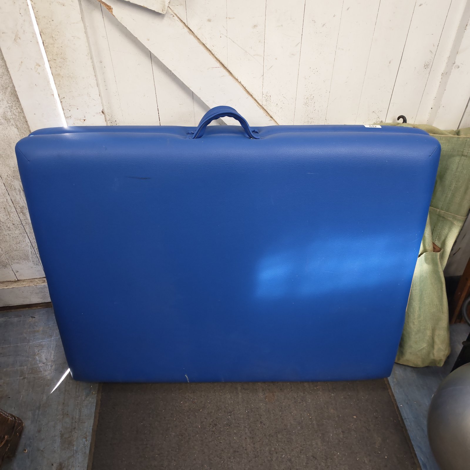 Blue leather folding massage table for spa or therapy use.