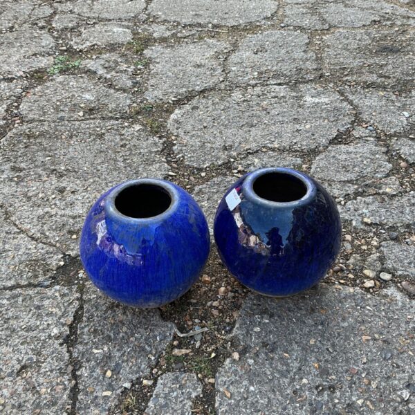 Pair of vibrant blue glazed garden pots for outdoor plants.