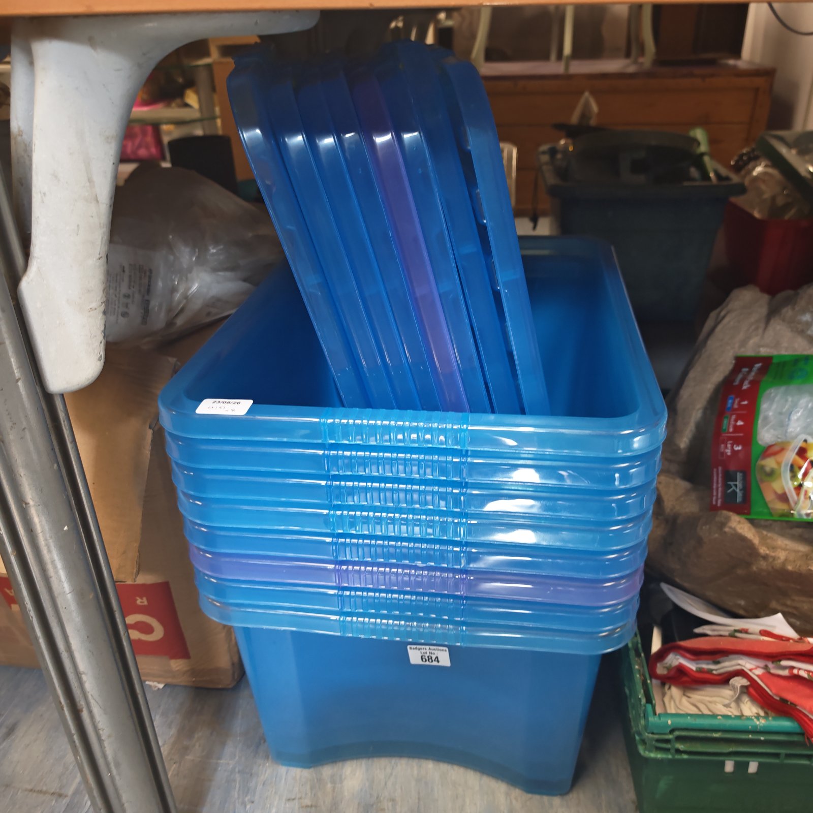 Stack of eight blue plastic storage boxes for household organization.