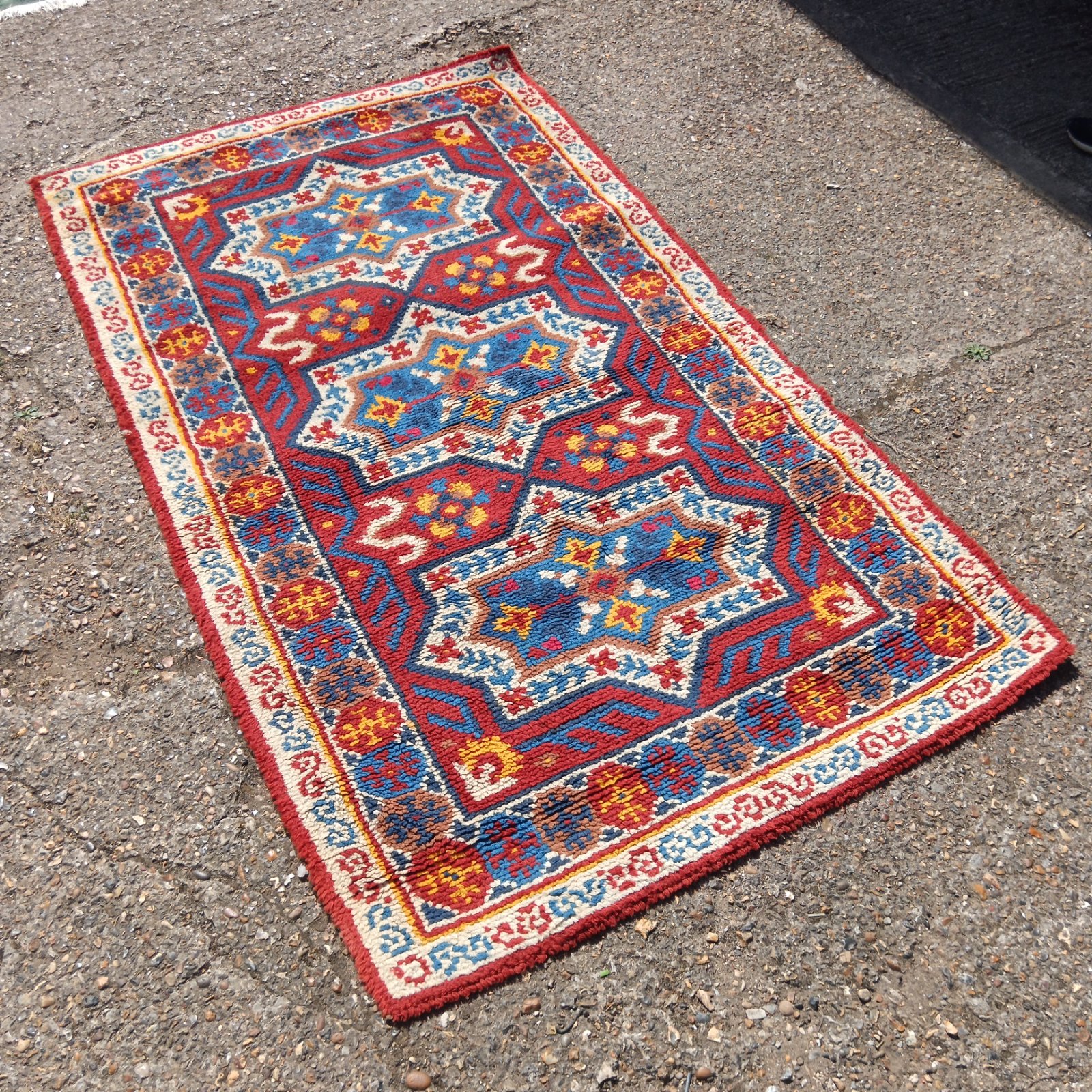 Vintage Kazak rug with blue and red geometric medallion pattern.