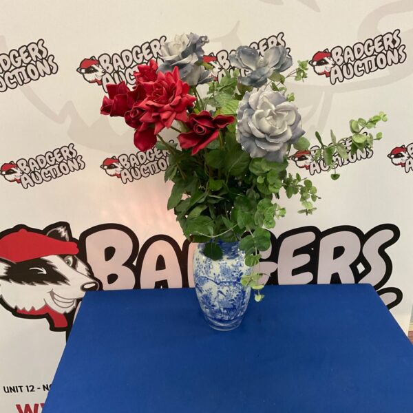 Blue and white porcelain vase with artificial flowers arrangement.