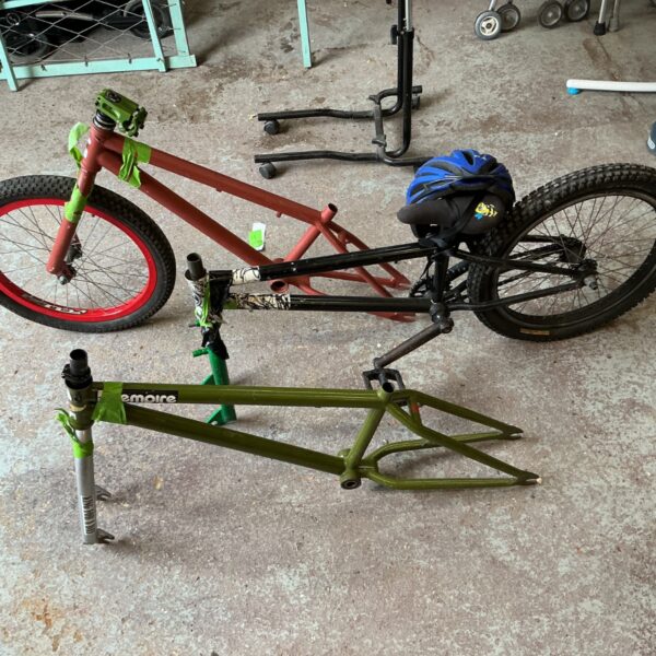 BMX frame lot with red wheel and green fork.