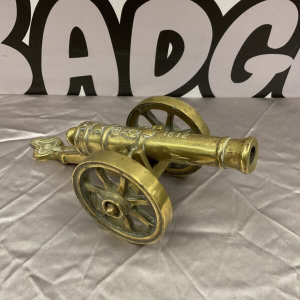 Detailed brass model cannon with 1812 marking.