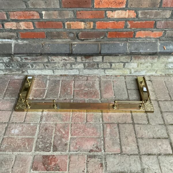 Ornate brass fireplace fender for hearth protection.