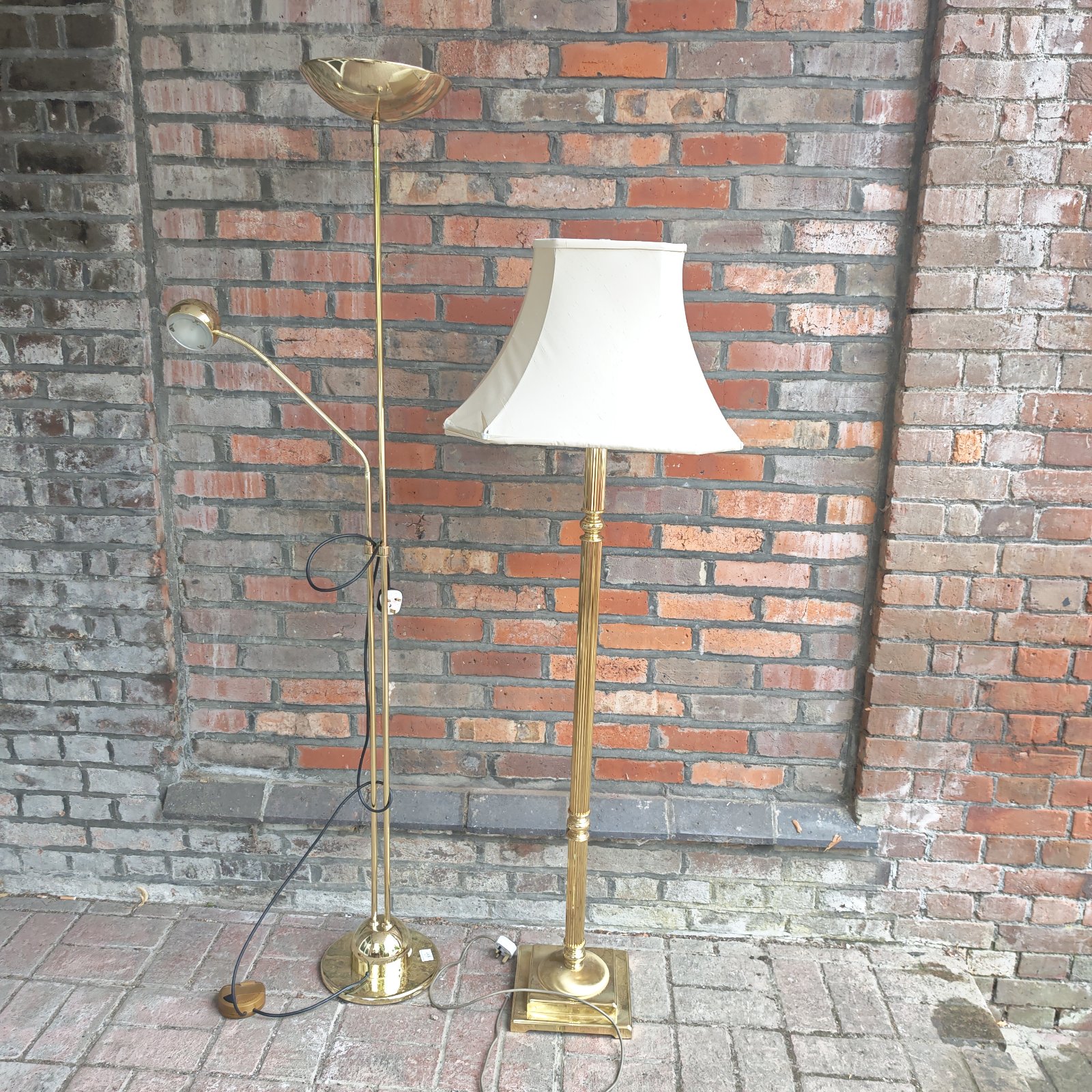 Vintage brass standard lamp with adjustable reading light in a home setting.