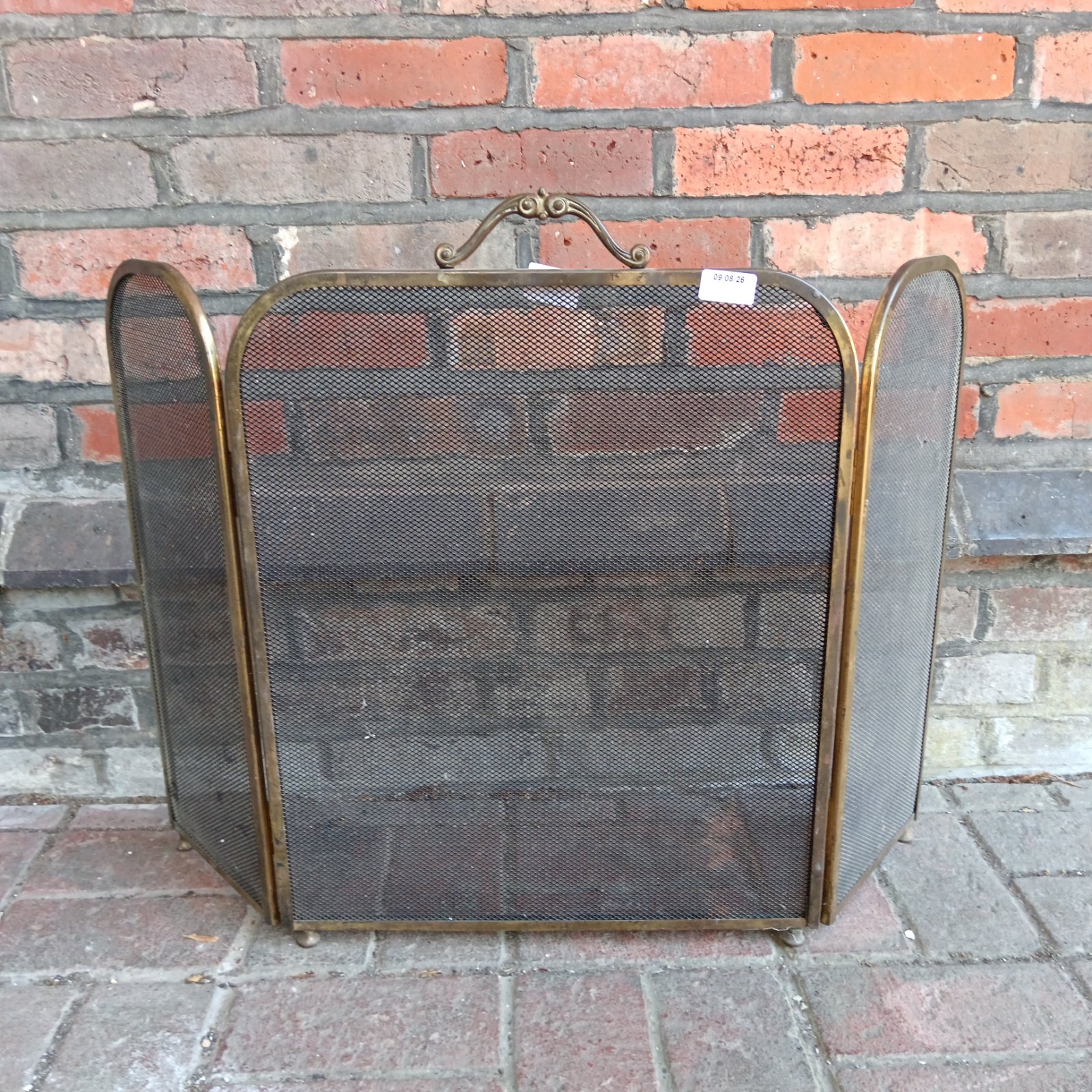 Vintage brass trifold fire screen for fireplace safety and decor.