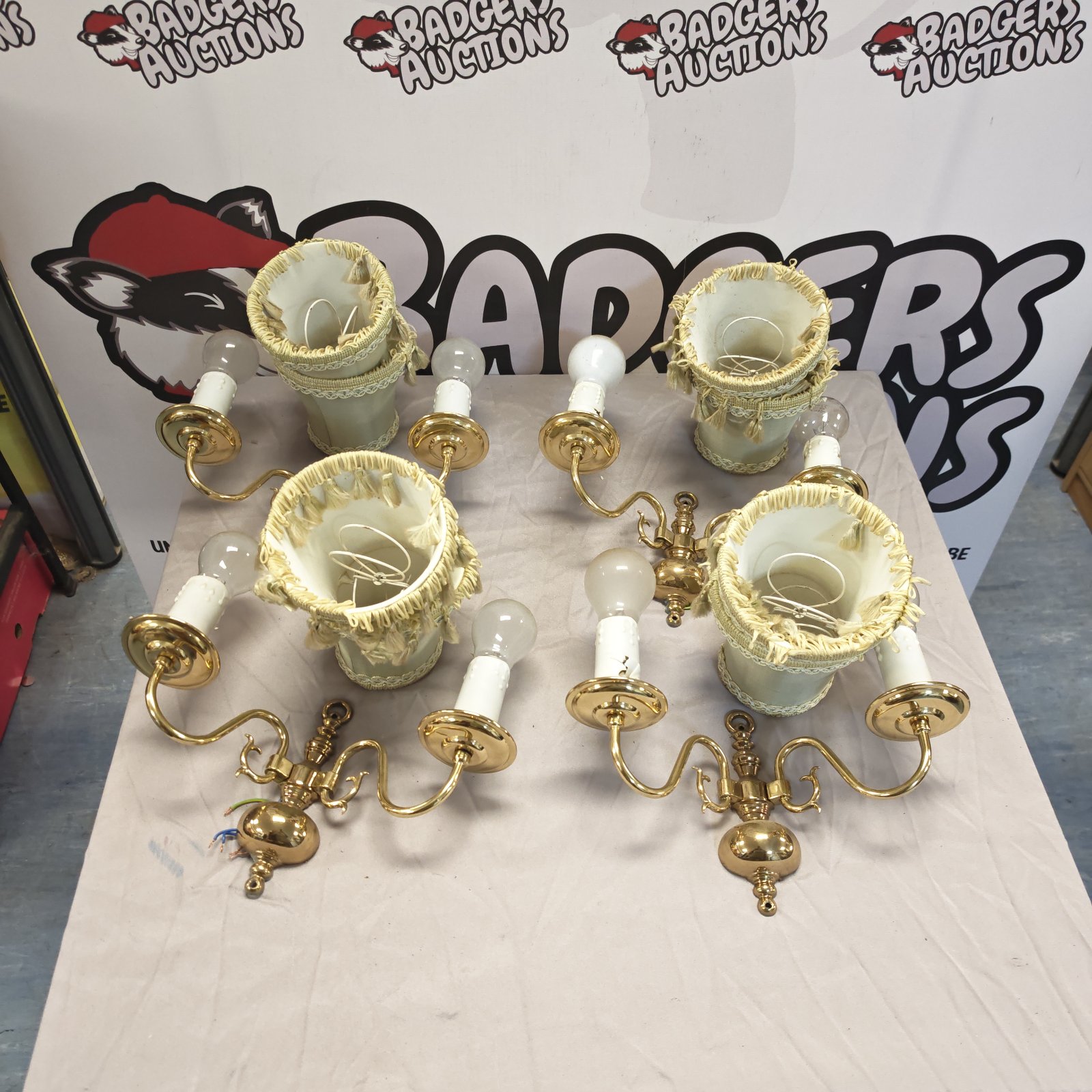 Vintage brass wall sconces lot with cream shades.