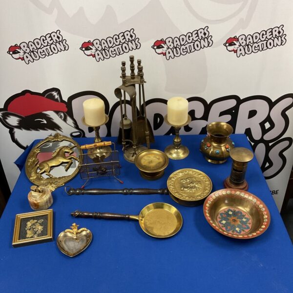 Vintage brassware collection featuring a fireplace set and unicorn mirror.