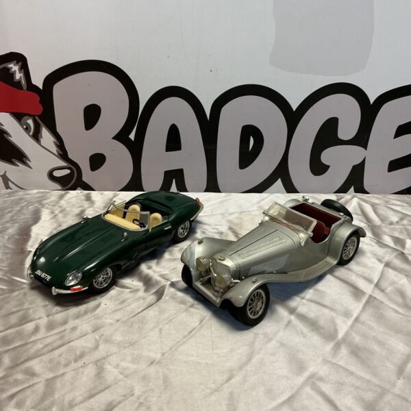 Vintage Burago Jaguar E Type and SS 100 model cars on display.