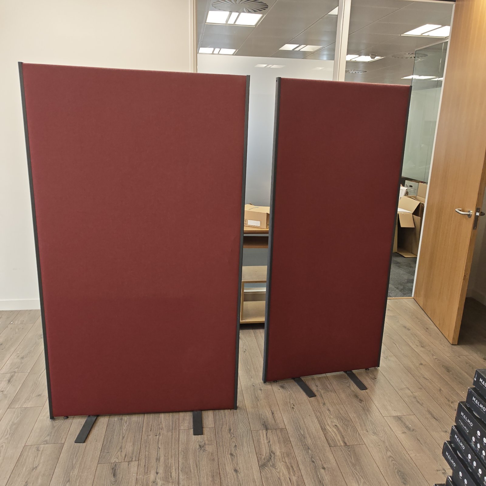Two burgundy office privacy screens for creating private workspaces.