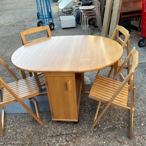 Light oak butterfly dining set with folding chairs and storage.